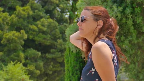 Detail einer schönen Frau mit Sonnenbrille, die einen sonnigen Tag genießt