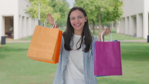 Smiling Woman Holding Shopping Bags Outdoors