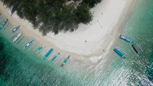 Amazing top view aerial detail shot of an island with white sand with boats on the shore. Sunshine g