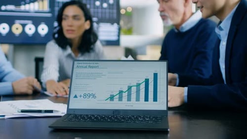 In the Meeting Room Laptop Standing on the Conference Desk Shows Company's Annual Growth Report wit