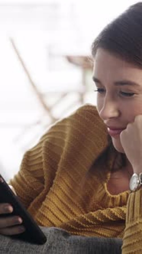 Smiling Young Woman Looking at Tablet Indoors Daytime