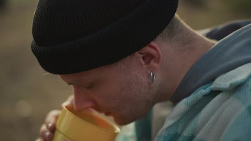 Traveler Enjoys Coffee Person Relaxes at Forest Campsite with Warm Drink Backpacker with Bright Mug