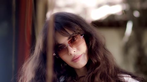 Stylish Woman Posing with Sunglasses in Urban Setting