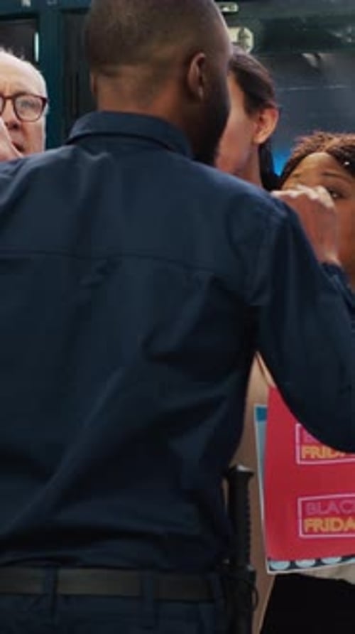 Police Officer Interacts with Group Holding Black Friday Sign