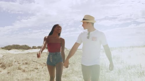 Young Attractive Couple Walking and Holding Hands with Sand Dunes and Wide