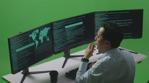 Tired Asian Man Developer Yawning While Write Code With Multiple Computer Screens In Green Screen