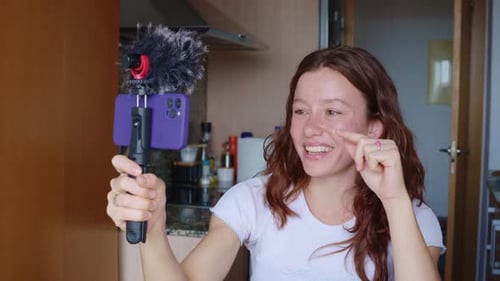 Junge Influencer streamen live zu Followern mit Handy und Mikrofon