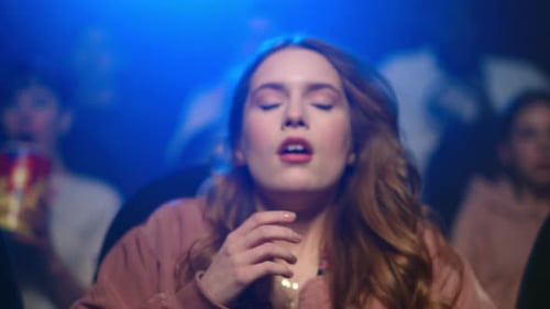 Closeup Beautiful Scared Woman Watching Horror Film In Dark Hall. Portrait Of Shocked Girl Jumpin...