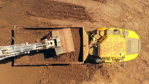 Excavator Loading Dirt into Industrial Dump Truck, Aerial