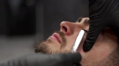 Barber Shaves Beard with Straight Razor, Close Up