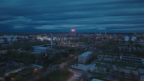 Aerial Night view of an industrial refinery with gas flares illuminating the dark sky (4K). Industry