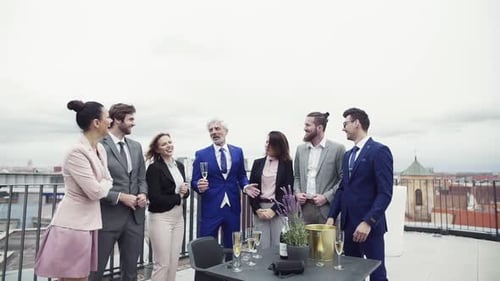 Empresários alegres comemoram o sucesso em uma festa ao ar livre no terraço da cidade