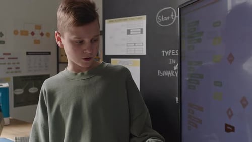 Junge hält Präsentation zum Programmierunterricht auf digitalem Bildschirm