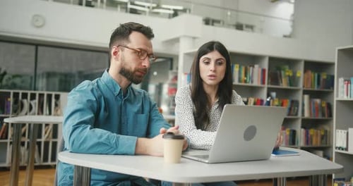 Man and Woman Studying Together at Library Table