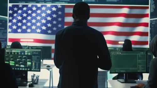 Programmers Working in Office with American Flag Backdrop