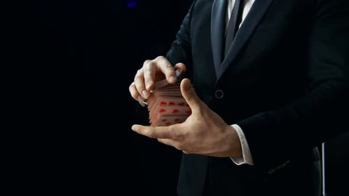 Close-up of a Magician's Hands Performing Card Trick. Throwing and Catching Cards Deck in the Air.