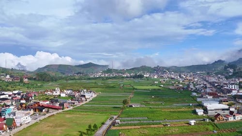 Aerial view of a beautiful highland town surrounded by lush green farmland