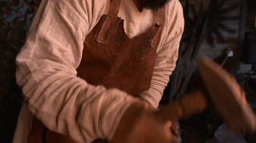 An adult man who works with iron. Media. Work with tapping on iron on special equipment