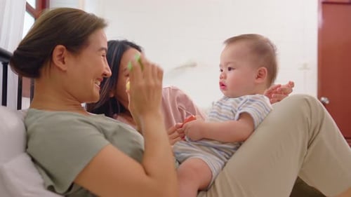 Two Women Playing with Baby at Home
