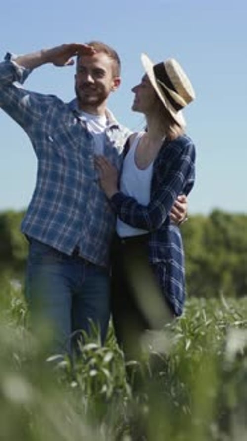 A Happy Couple Captures Memories in a Sunlit Field Smiling
