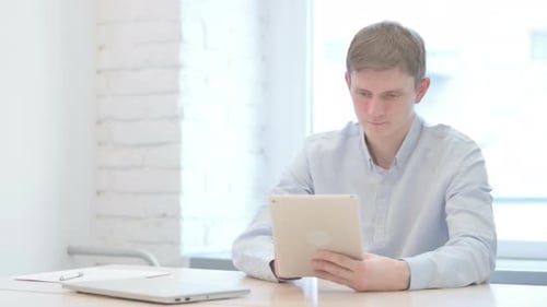 Man Working on Tablet at Minimalist Workspace