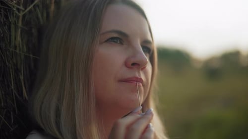 Woman Outdoors with Hay at Golden Hour