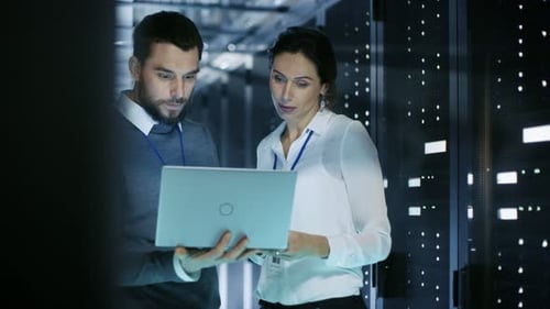 Two Colleagues Reviewing Laptop in Data Center