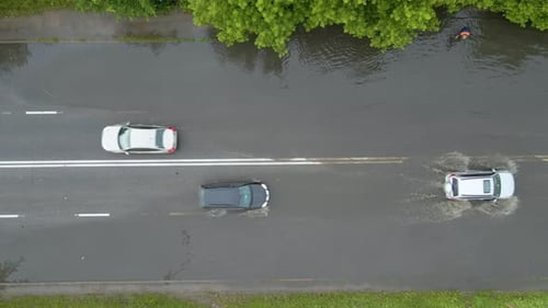 Aerial View of City Traffic with Cars Driving on Flooded Street After Heavy Rain