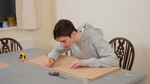 Boy Measuring Wooden Board with Tape Measure for Accurate Cutting Male Student Marking Precise Lines