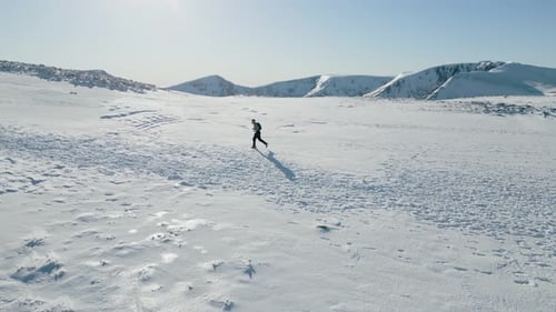 Athlete Training in High Mountains on vast Plateau of Snow