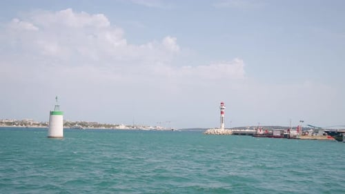 Seehafen, Hafen und Leuchtturm auf blauem, bewölktem Himmelshintergrund. Aktion. Kreuzfahrtschiffe
