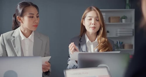 Empresários e empresárias asiáticos se reunindo para debater ideias sobre projetos trabalhando juntos.