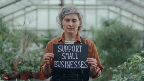 Woman Stands in Greenhouse Supporting Small Businesses