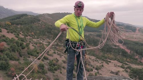 Man Prepares Climbing Rope Outdoors in Nature