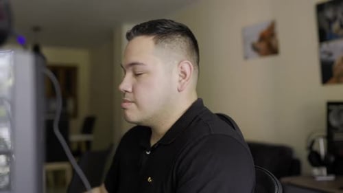 Man Drinking Coffee at Computer in Home