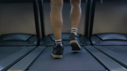 Back View Legs In Sneakers Walk on Treadmill in Fitness Gym Unknown Man Going Footstep Sport Runner