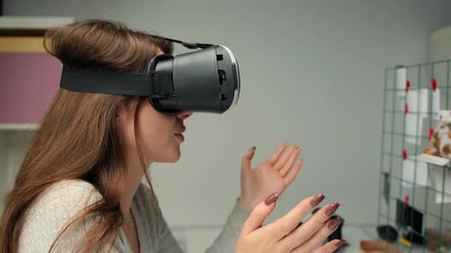 Young woman office worker uses virtual reality glasses in office interior