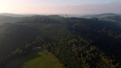 Aerial view of 5G tower base telecom station in a remote area on the top of the hill in wild evergre