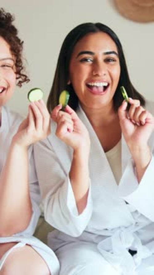 Smiling Women Holding Cucumber Slices in White Robes