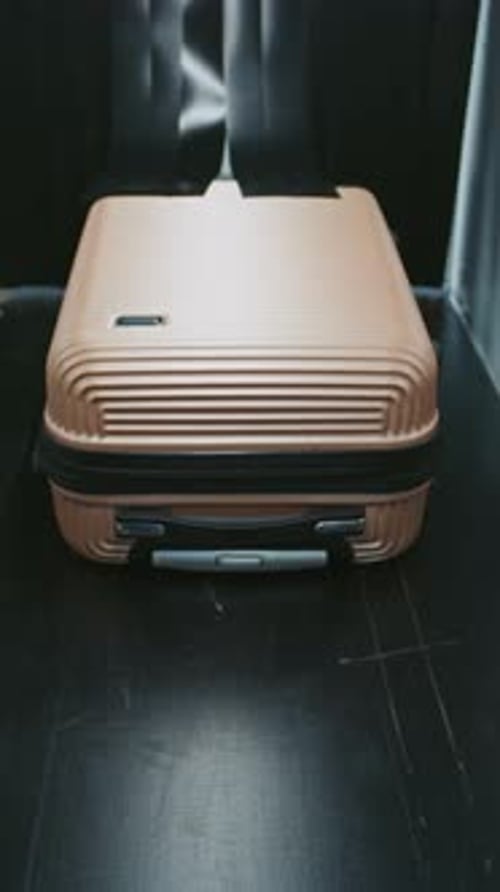 Bronze Suitcase Advances Toward Camera