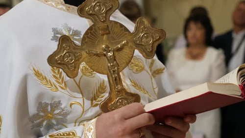 A49. The priest preaches holding a bible and a cross.