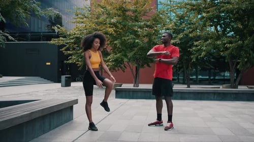 Athletic Man and Woman Stretching Outdoors