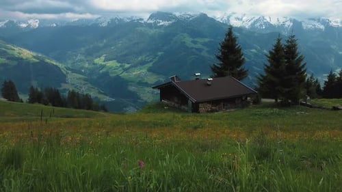 Aerial drone along a cottage lodge cabin and trees in nature at scenic Zillertal skiing sport hiking