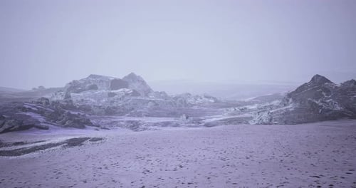 Weitläufige, schneebedeckte Winterlandschaft mit schroffen Felsformationen