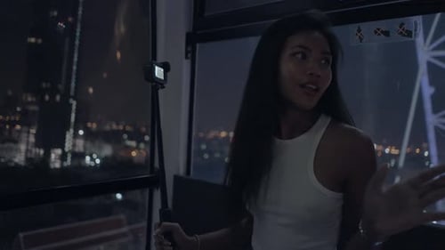 Videoblogger Describing the View to Her Followers at the Ferris Wheel Action Camera Holding and
