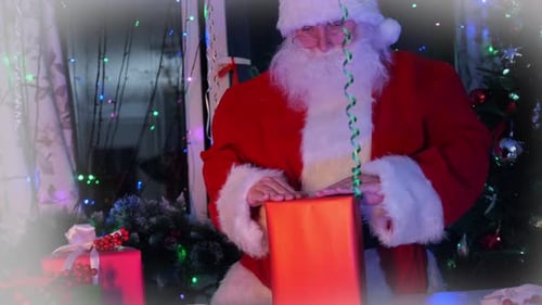 Santa wraps a present in red paper in his workshop decorated with Christmas decorations