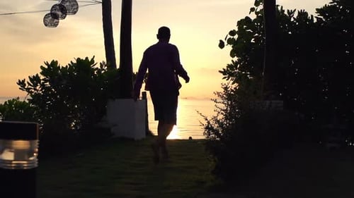 Man walks in exotic garden enjoying golden sunset and a relaxed lifestyle