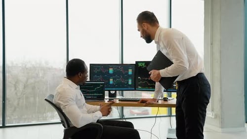 Zwei Aktienhändler arbeiten im Büro mit Börsentechnologie