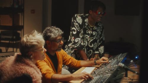 Sound Engineer and Musicians Discussing Audio Project in Recording Studio