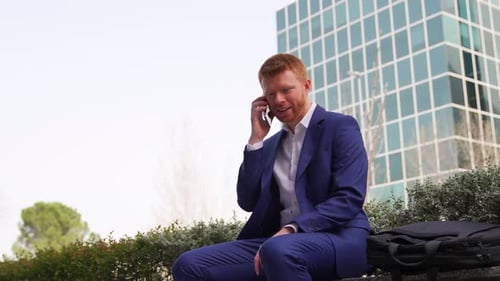 Man Talking on Cellphone Outside Office Building